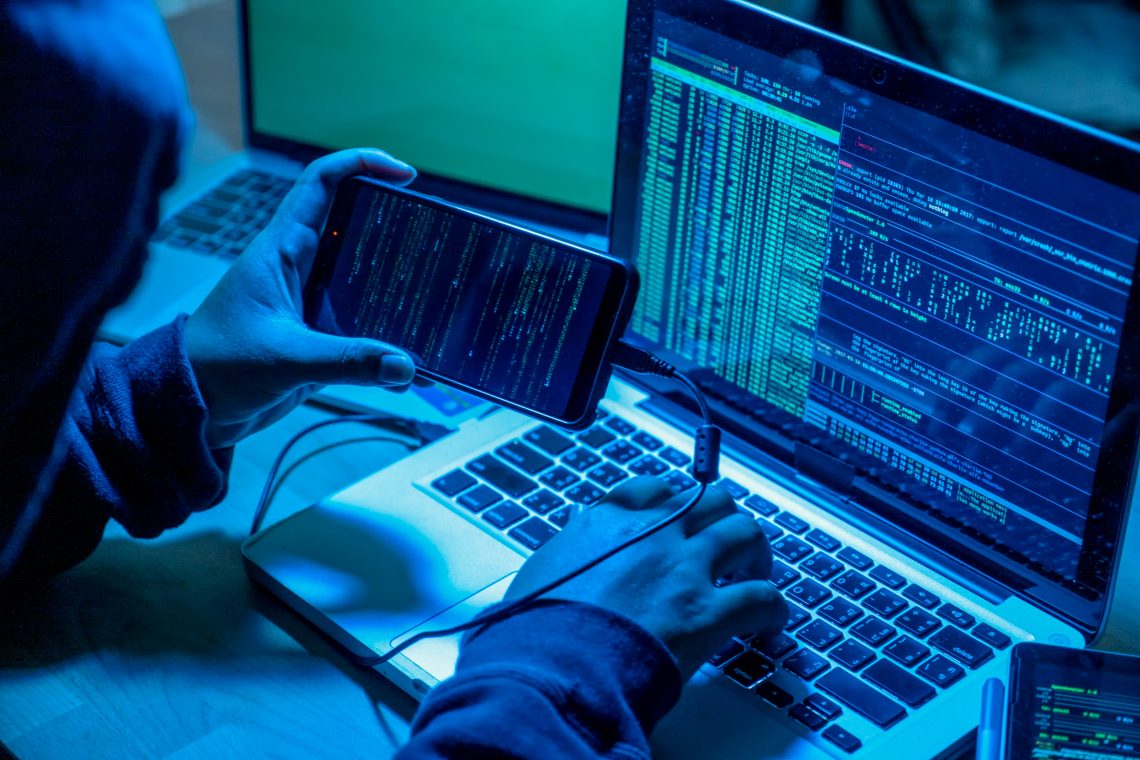 Ein Hacker vor einem Computer in einem dunklen Raum