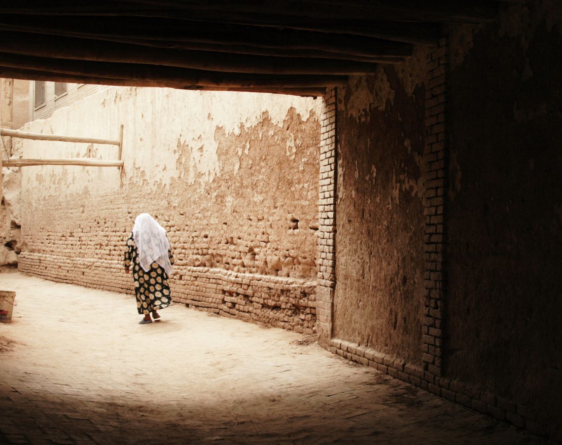 Uigur Frau läuft durch eine verlassene Gasse