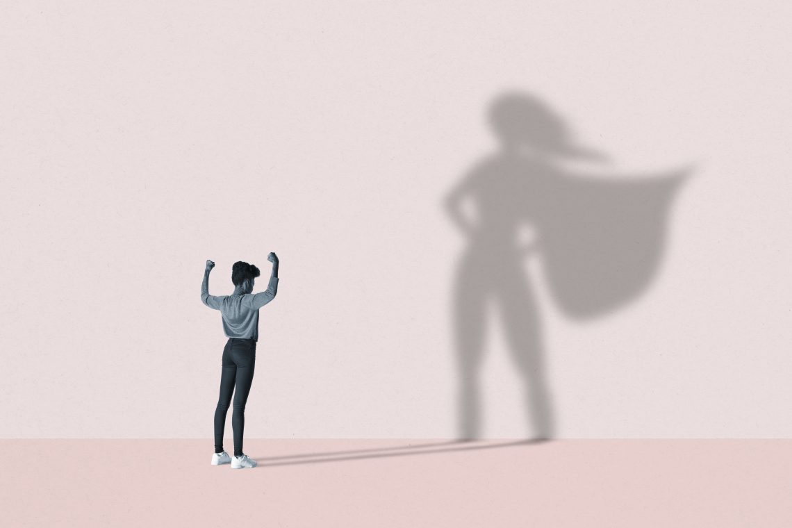 Illustration eines Mädchens vor einer Wand mit Superheldin-Schatten.