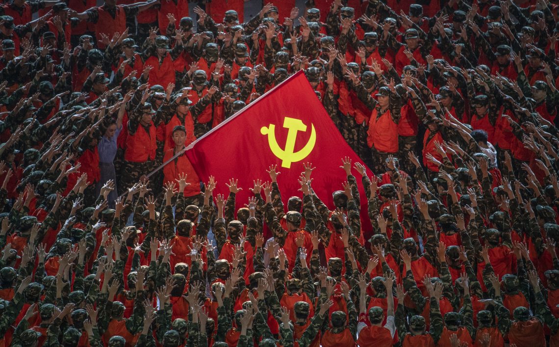 Eine Menschenmenge ist um die Flagge der Kommunistischen Partei Chinas gruppiert