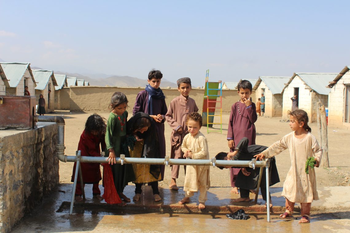 Flüchtlingskinder an einem Brunnen