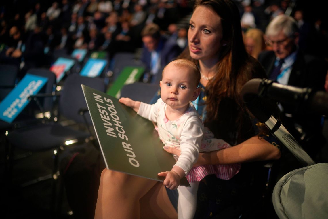 Baby auf dem Schoß seiner Mutter während einer Parteisitzung in Manchester, 2019