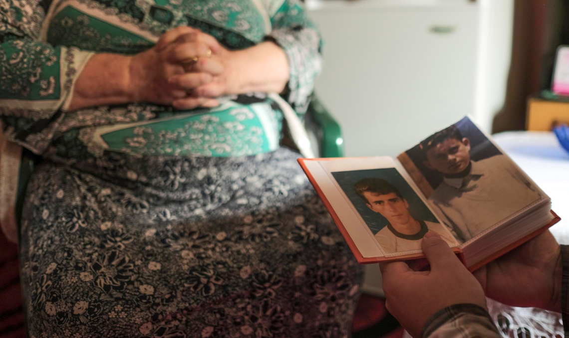 Frau in Bosnien zeigt Fotos ihrer verstorbenen Söhne