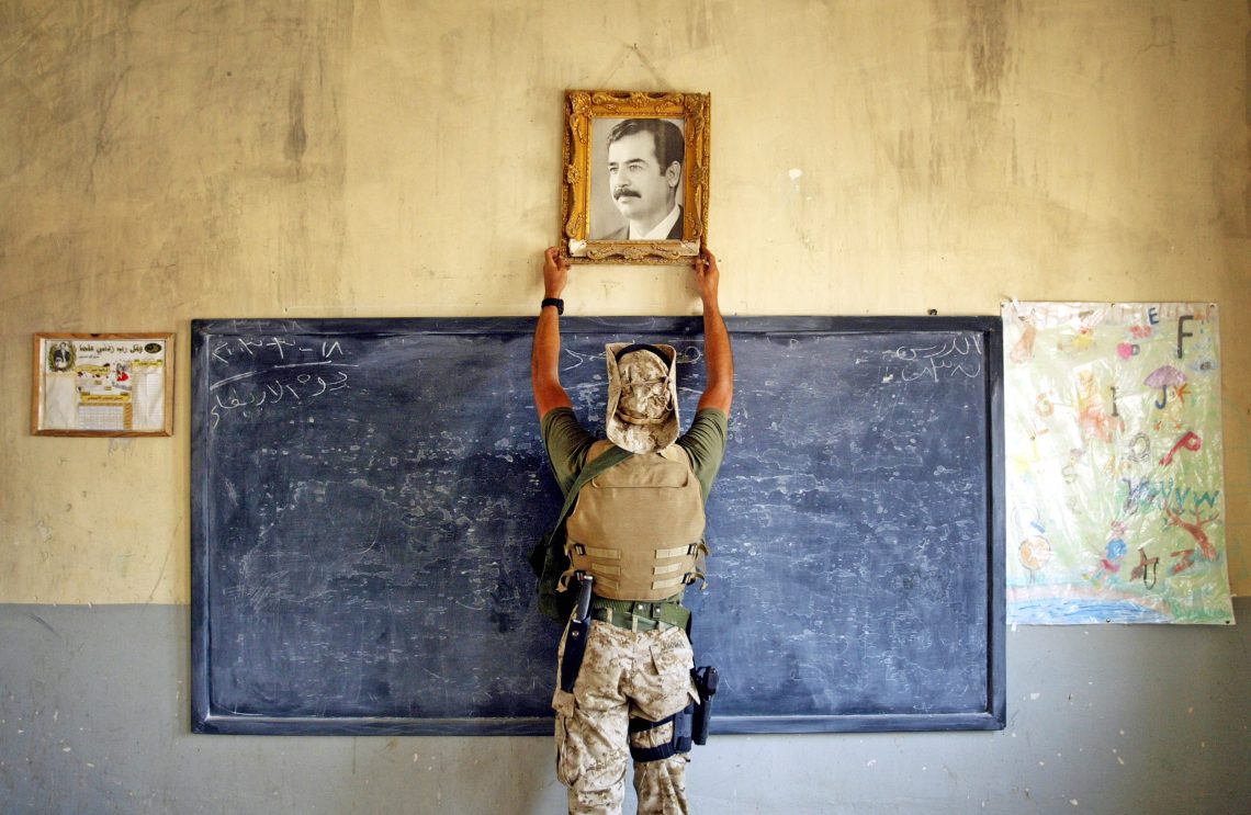 Friedensordnung im Krieg: Ein US-Marine entfernt ein Bild von Saddam Hussein in einer Schule in Al-Kut, Irak.