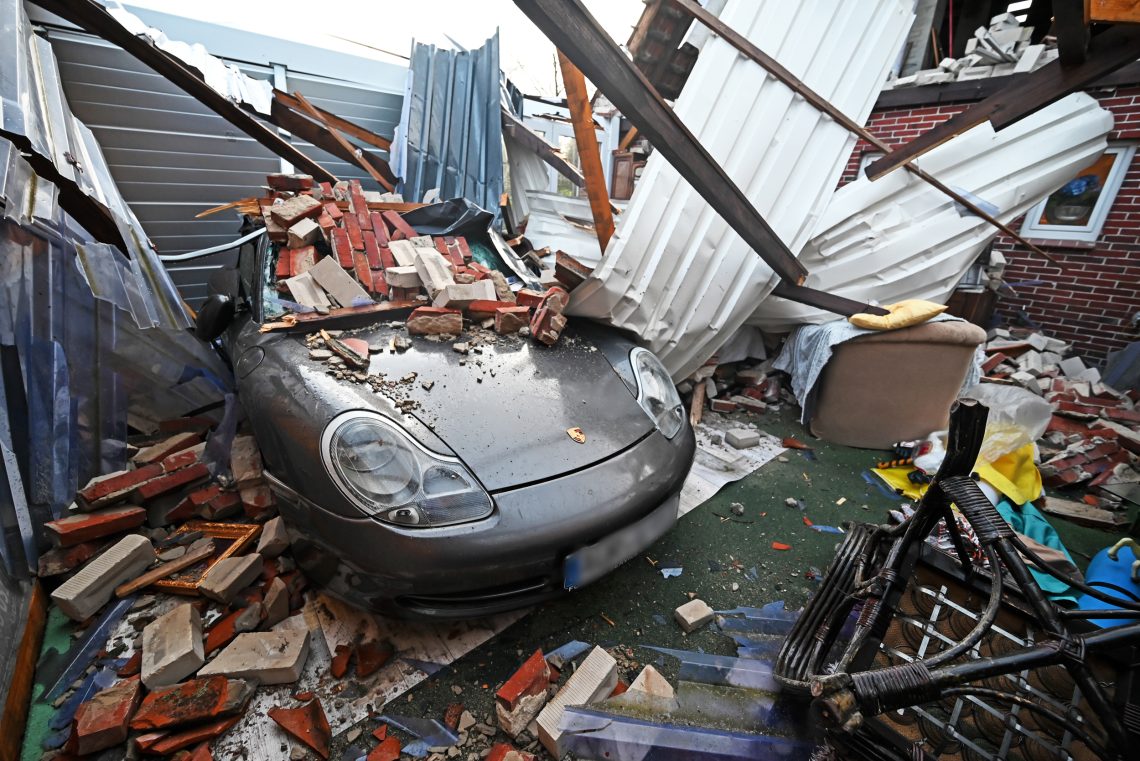 19. Februar 2022, Niedersachsen, Eversmeer: Die Reste eines eingestürzten Daches liegen nach Orkan Zeynep auf einem Porsche