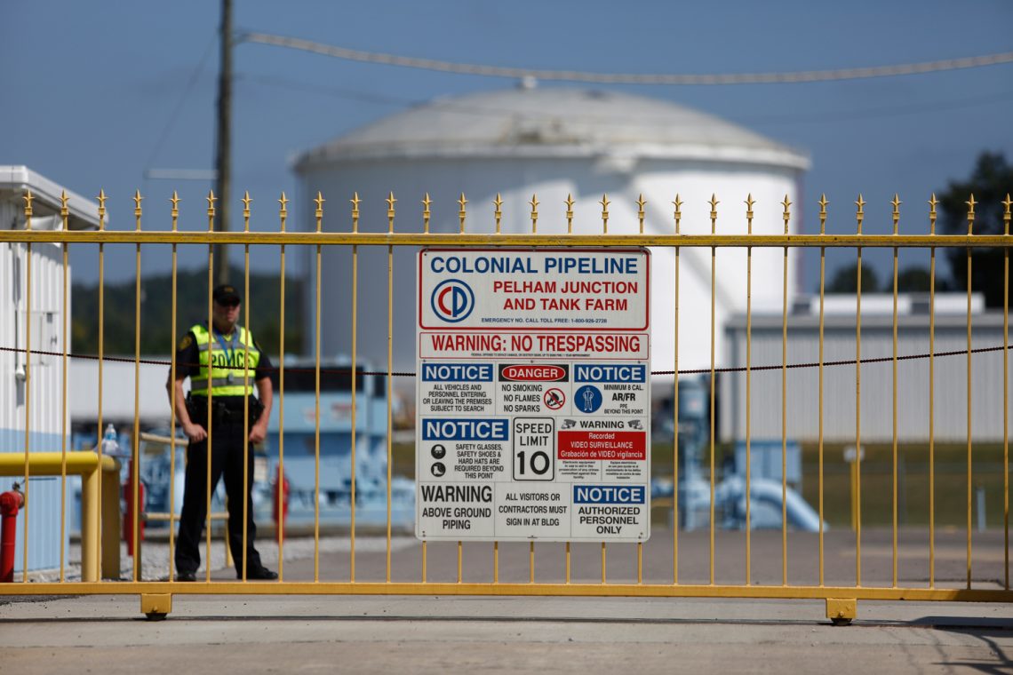 Ransomware: Foto des Eingangstores zu einer Ölraffinerie mit großen Öltanksin den USA mit Warnschildern.