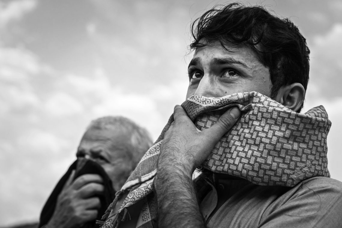 Weinender Afghane bei einem Massenbegräbnis für eine Familie, die durch einen US-Drohnenangriff getötet wurde