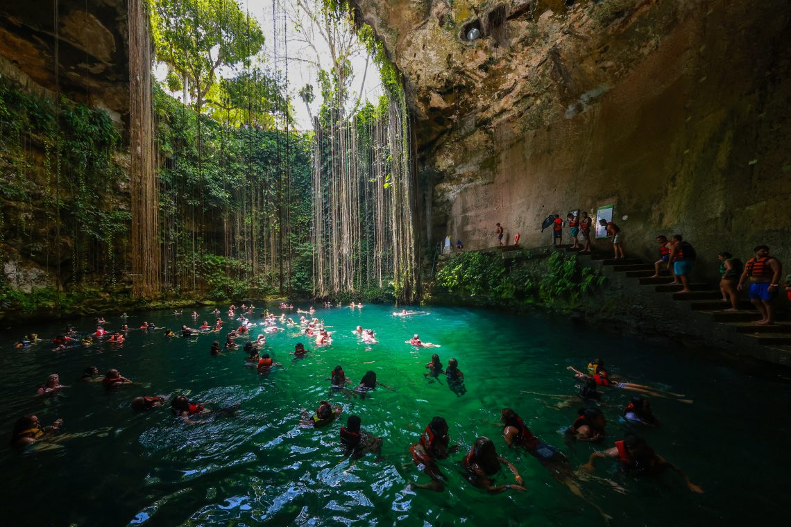 Foto von vielen Menschen, die in Yucatán, Mexiko, in einem der Höhlenseen schwimmen.
