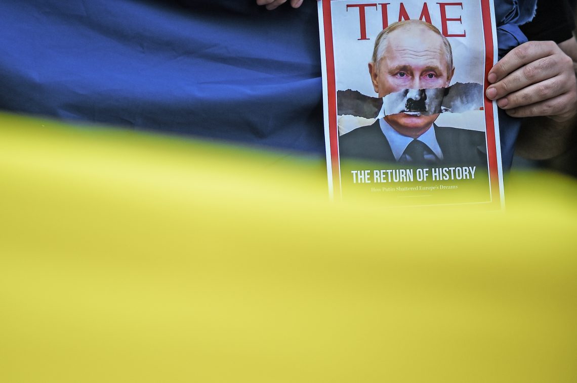 Time Cover, das Putin als Hitler zeigt, hinter einer ukrainischen Flagge