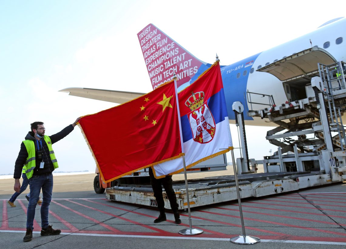 Chinesische und serbische Flagge vor einem Flugzeug mit einer chinesischen Covid-Impfstoff-Lieferung am Flughafen Belgrad, 2021
