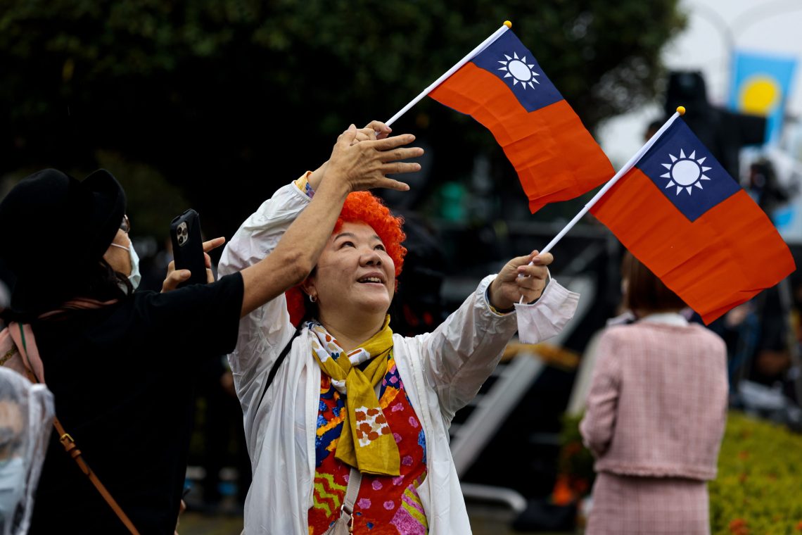 Taiwan Krieg: Foto von zwei Frauen, die Fahnen von Taiwan schwenken.