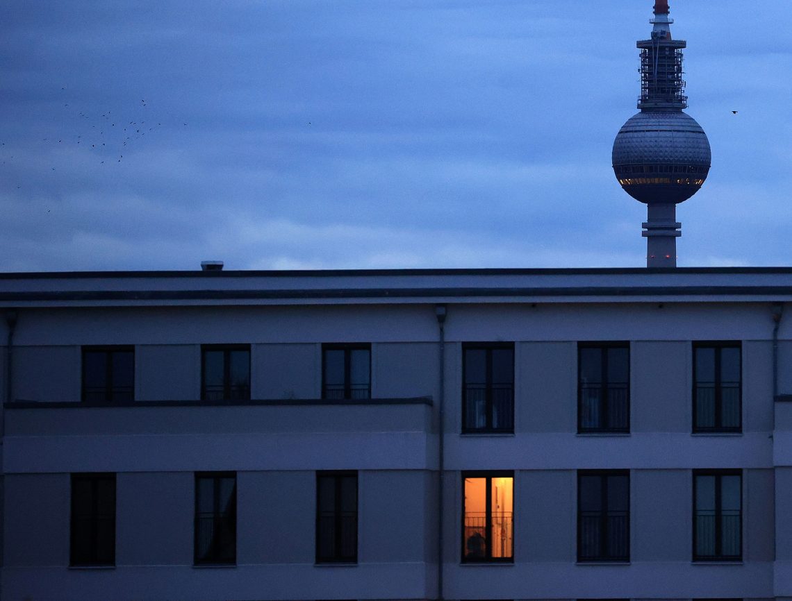 Foto des Fernsehturms in Berlin in der Abenddämmerung mit einem Haus im Vordergrund, von dessen vielen Fenstern nur eines beleuchtet ist.Manche sprechen davon, dass Duneklflauten drohen, sollte die Energiewende umgesetzt werden.