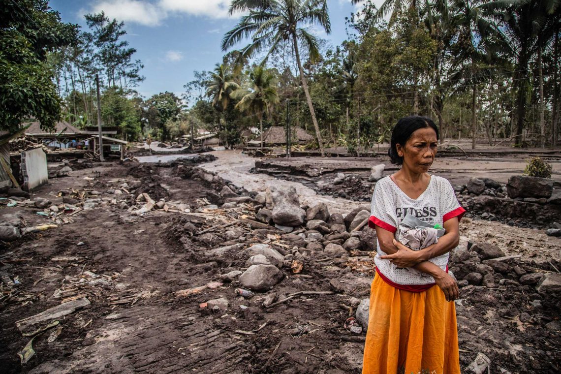 Eine Frau betrachtet ihr Haus, das im September 2021 von Vulkanasche auf der indonesischen Insel Java verschüttet wurde.