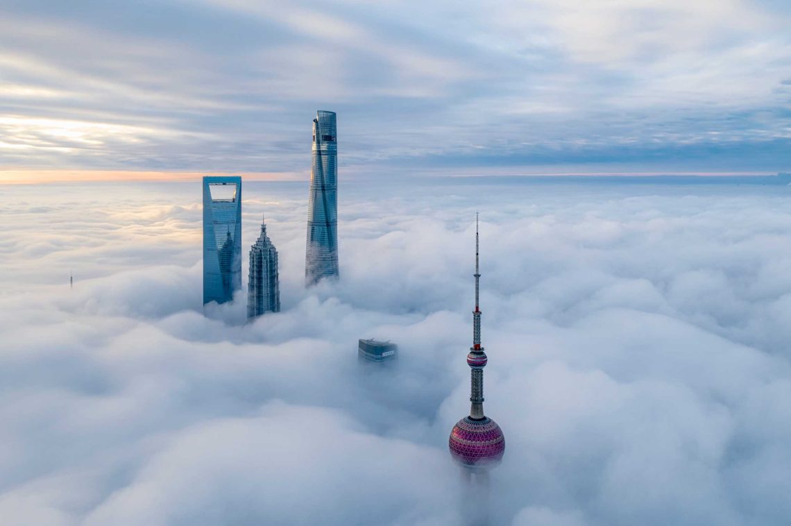 Die Spitzen der modernsten und höchsten Gebäude Chinas ragen aus demWolkenmeer über Schanghai.
