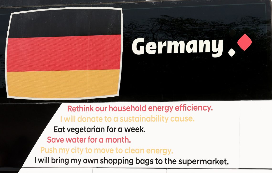 Foto einer Aufschrift in englischer Sprache: DIe deutsche Nationalflagge  und darunter in den Nationalfarben  eine Liste mit Empfehlungen wie zum Beispiel "Die Energieeffizienz des Haushalts überdenken."