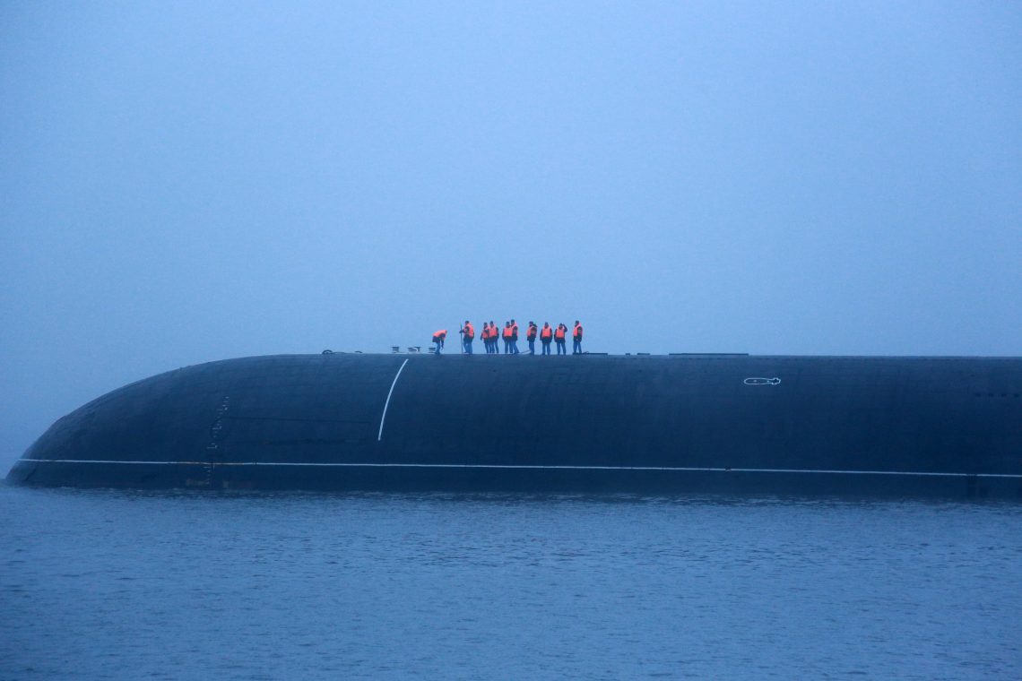 Das mit Atomraketen bestückte U-Boot Dmitriy Donskoy trifft in dichtem Nebel in Sankt Petersburg ein. An Deck stehen Matrosen mit orangen Warnwesten.