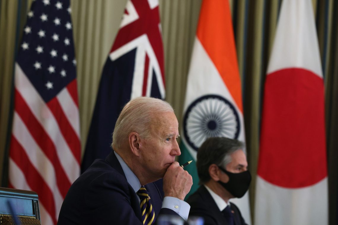 US-Präsident Joe Biden sitzt nachdenklich vor den Flaggen der USA, Australiens, Indiens und Japans bei einem Treffen der sogenannten Quad, einer losen Allianz der vier Länder, um China die Stirn zu bieten.