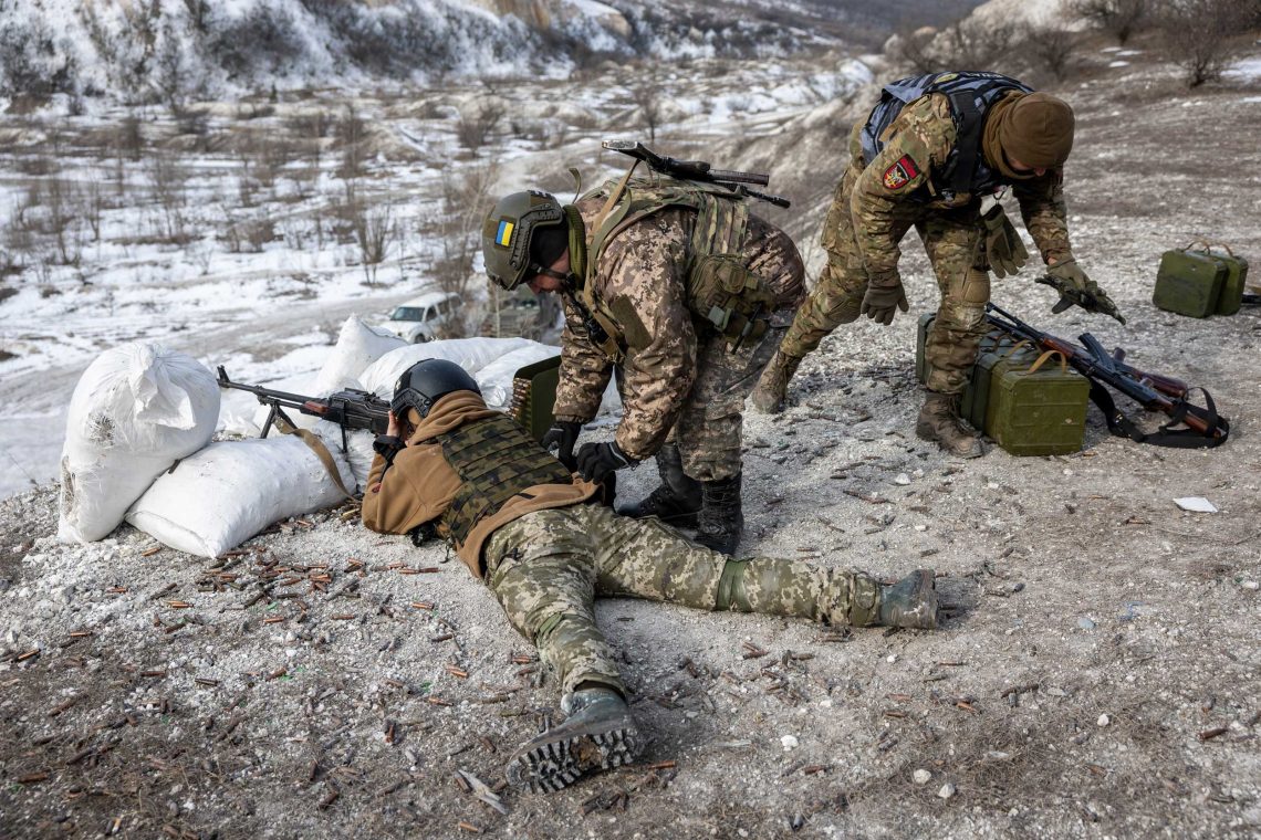 Foto von Soldaten, die teilweise auf dem Boden liegend das Schießen mit einem Maschinengewehr üben. Das Bild illustriert einen Kommentar über die Frage, wie man Söldner bezahlt.