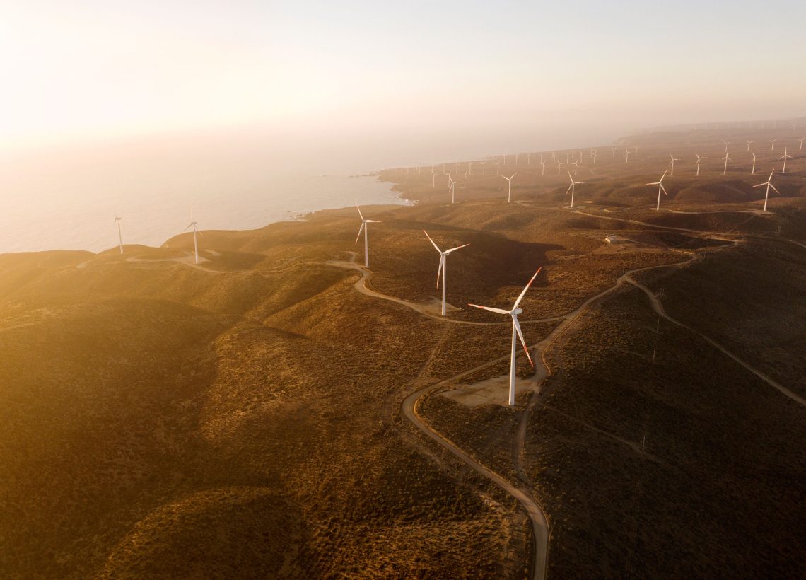 Foto von vielen Windrädern an einer Küste. Das Bild zeigt die Energieversorgung und gehört zu einem Beitrag über Wüstenstrom.
