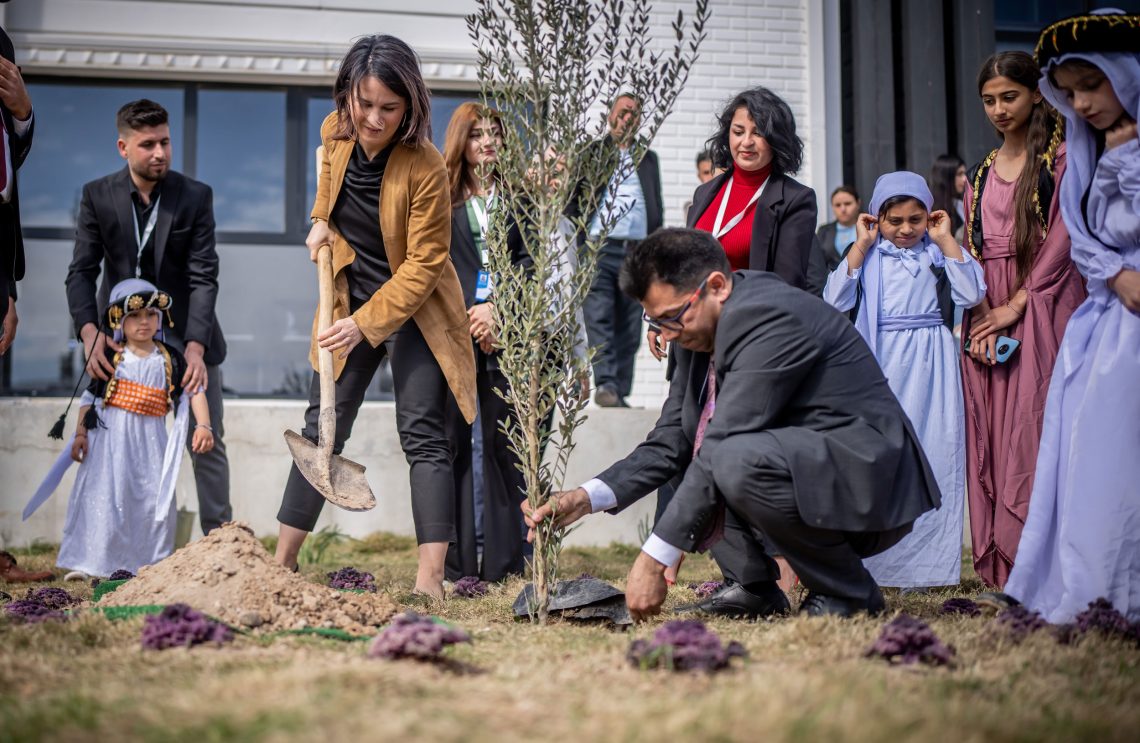 Irak, März 2023: Die deutsche Außenministerin Annalena Baerbock pflanzt mit Mirza Dinnayi, Gründer des kulturellen und sozialen Begegnungszentrums „House of Coexistence“, einen Baum.