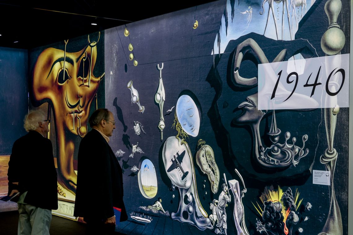 Zwei Museumsbesucher betrachten eine Installation von Werken des Surrealisten Salavdor Dali.