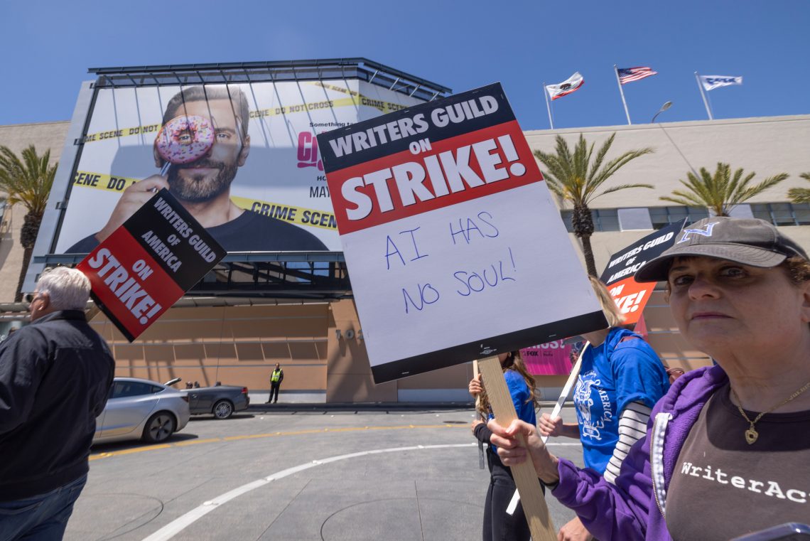 Eine Autorin streikt vor den Fox Studios in Hollywood. Auf ihrem Schild steht: „KI hat keine Seele”