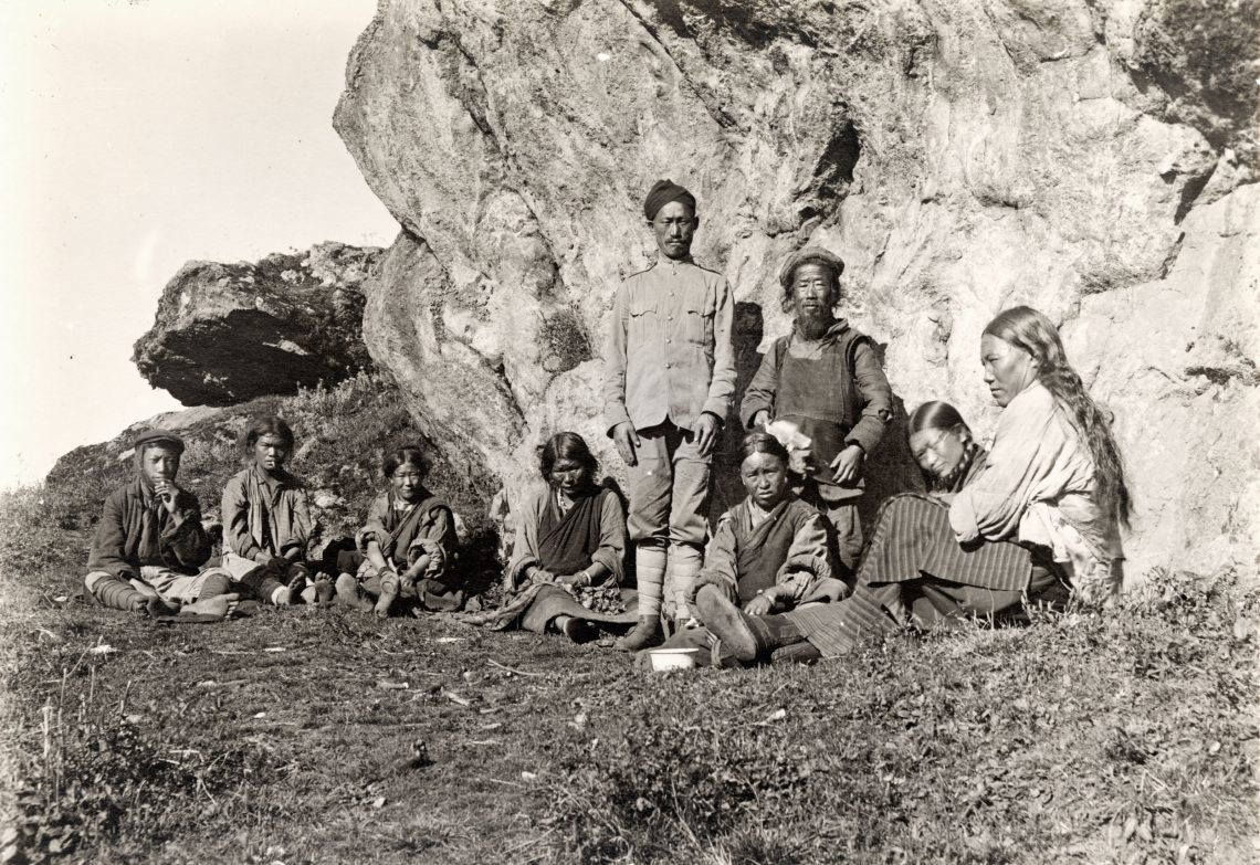 Eine Gruppe von Menschen posiert für ein Foto vor einem Felsen.