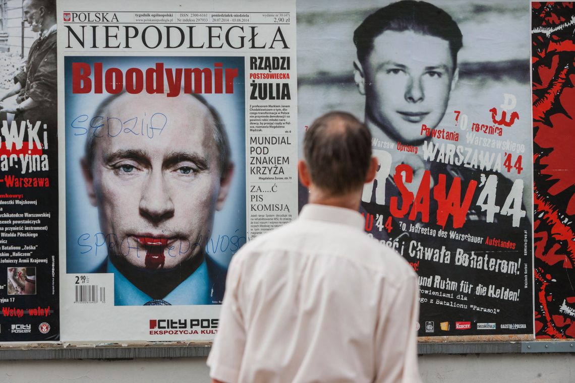 Mann vor einem Anti-Putin-Poster in Warschau, 2014