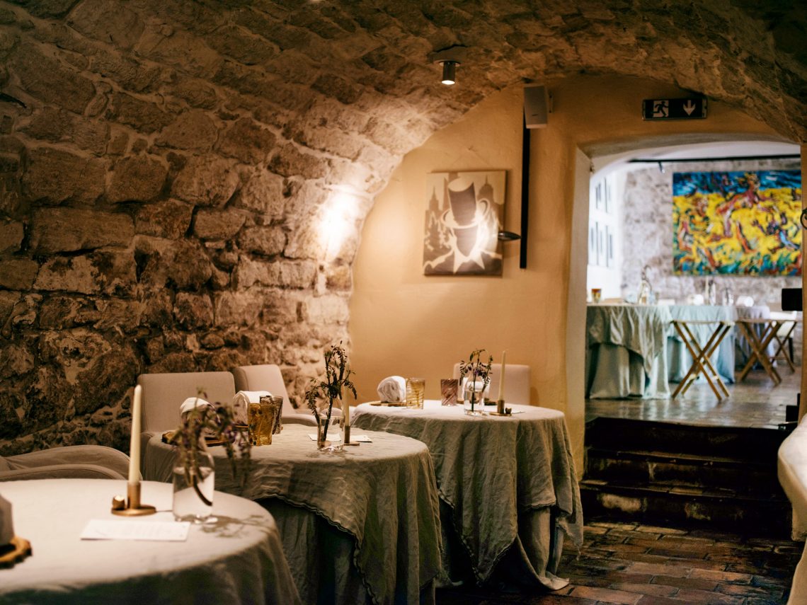 Haubenlokal Taubenkobel: Schön gedeckte Tische in einem altem Steingemäuer, an den Wänden hängt moderne Kunst.