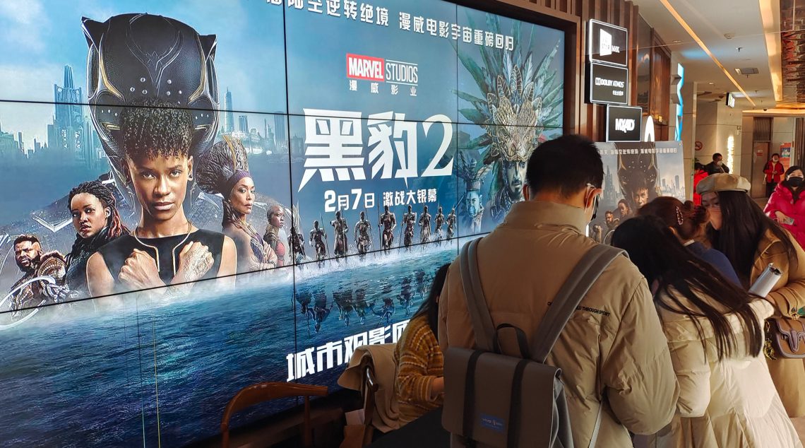 Menschen vor einem Poster des Science-Fiction-Films Black Panther 2 von Marvel in einem Kino in Shanghai, China, am 7. Februar 2023.