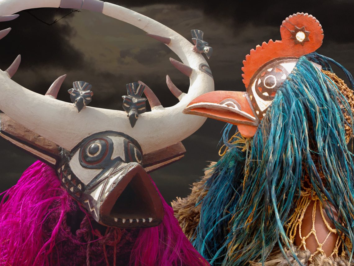 Zwei Maskierte Tänzer, einer mit einer Büffel-Maske und einer mit Vogelmaske, verkörpern Tiergeister bei einem Fest der Asama in Dédougou, Burkina Faso.