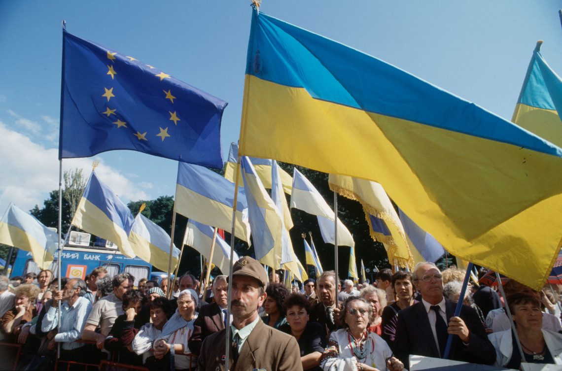 Demonstrierende mit ukrainischen Flaggen und der Fahne der Europäischen Gemeinschaft.