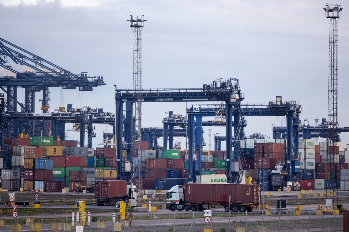 Lastwagen und Schiffscontainer im Hafen von Felixstowe in Felixstowe, Großbritannien. Die EU-weite Lieferkettenrichtlinie zielt darauf ab, dass Unternehmen künftig auch die Sublieferanten ihrer Lieferanten zu prüfen.