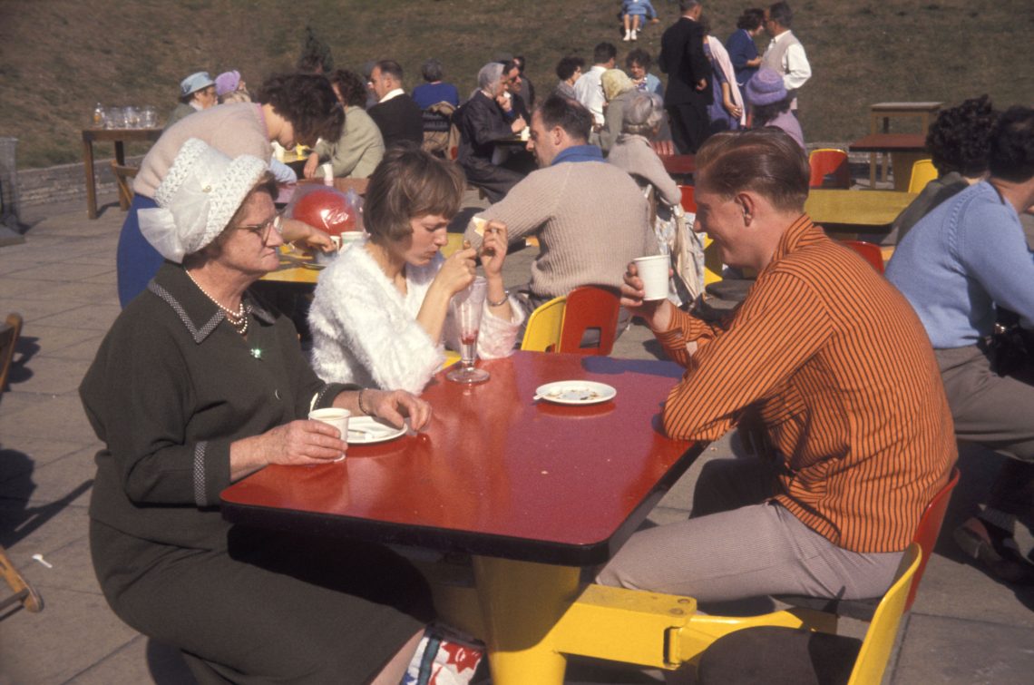 Eine Familie sitzt an einem Picknicktisch und unterhält sich. Das Bild ist Teil eines Beitrags über Essen und Politik. Es geht um die Ankündigung eines Podcasts mit dem Historiker Peter Peter.