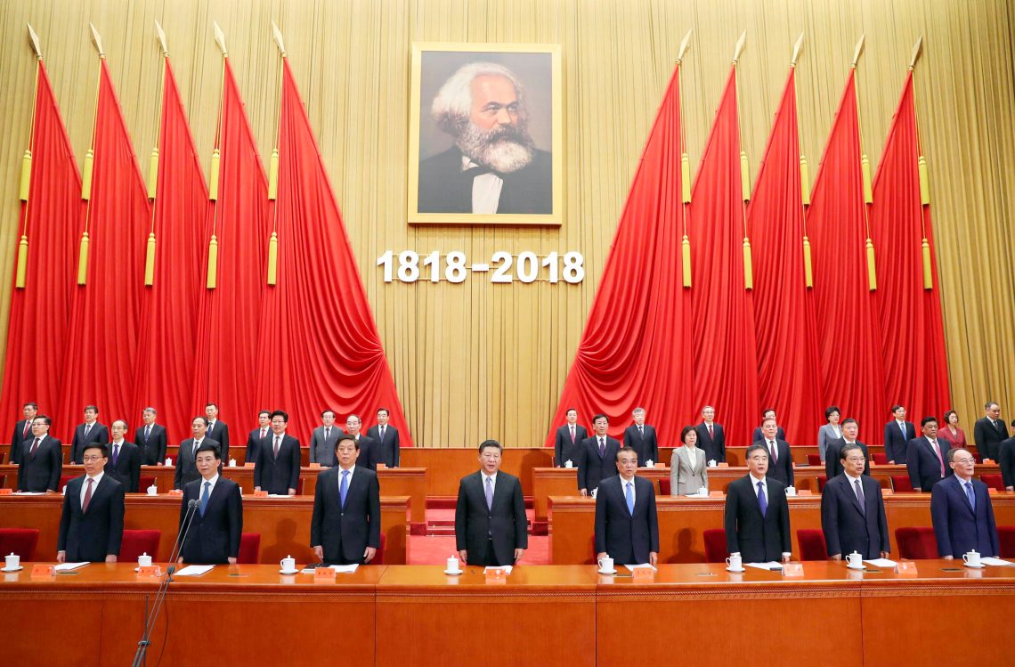Cinas Präsident Xi Jinping steht mit hohen Partei-Kadern unter einem Porträt von Karl Marx gesäumt von roten Flaggen anlässlich des 200. Geburtstags des deutschen Vordenkeers des Sozialsmus.