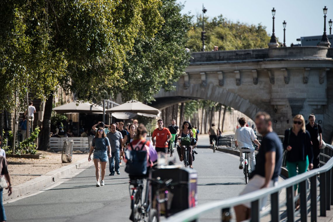 Menschen fahren Rad und gehen zu Fuß am Ufer der Seine in Paris.