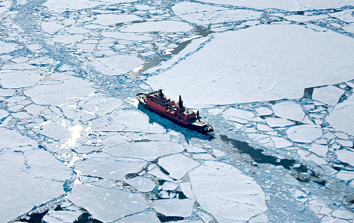 Ein russischer Eisbrecher aus der Vogelperspektive zieht eine Bahn durch arktische Eisschollen. Das Bild illustriert einen Beitrag über Putins Ambitionen in der Polarregion.