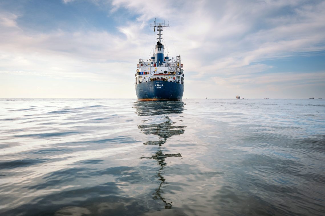 Ein Frachtschiff auf einem ruhigen Gewässer. Das Bild illustriert einen Beitrag zum Thema Sicherheit mit Florence Gaub.