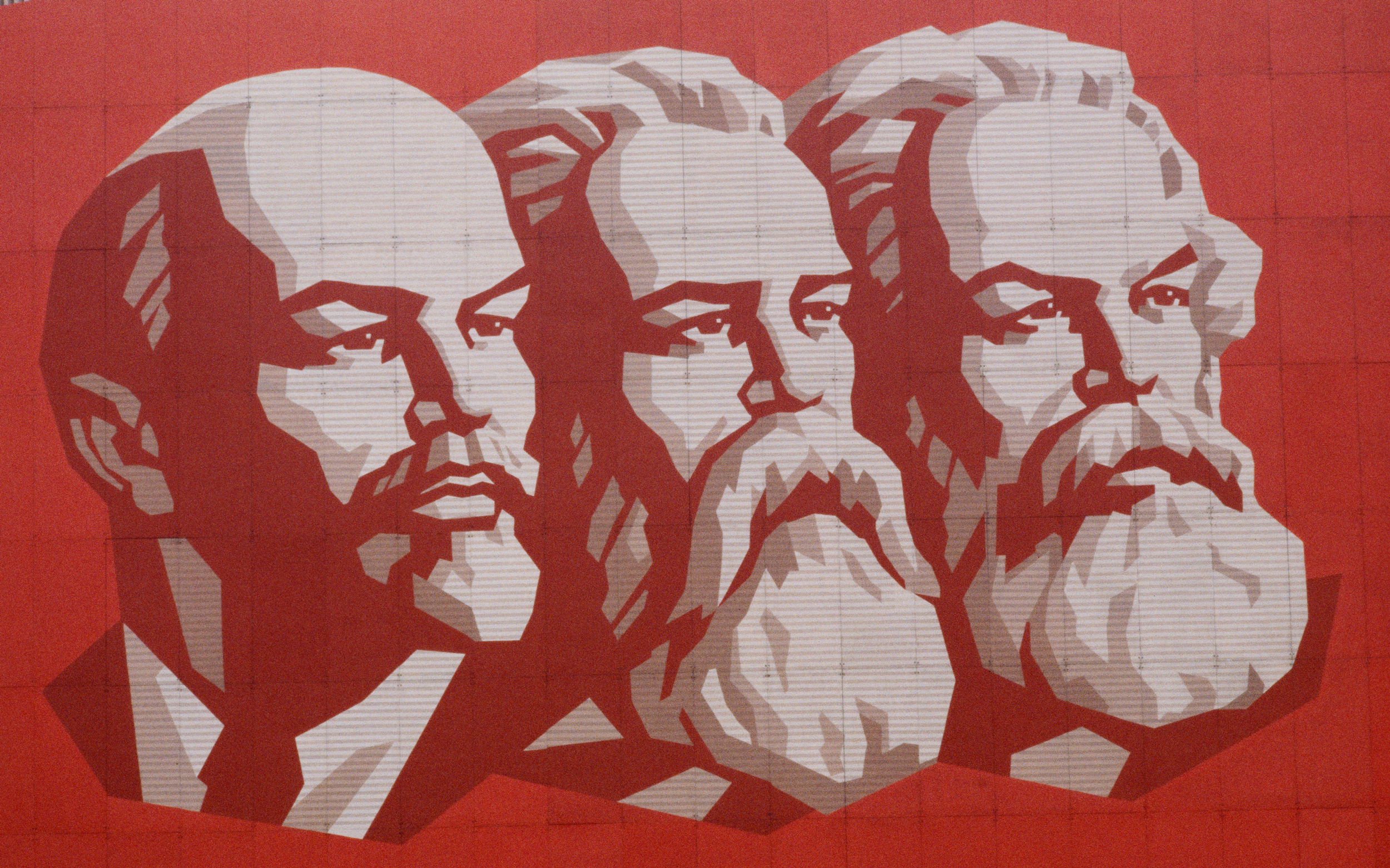 Plakat mit Wladimir Lenin, Friedrich Engels und Karl Marx anlässlich des 65. Jahrestags der russischen Oktoberrevolution. Das Bild illustriert einen Kommentar über die KPÖ und den Kommunismus.