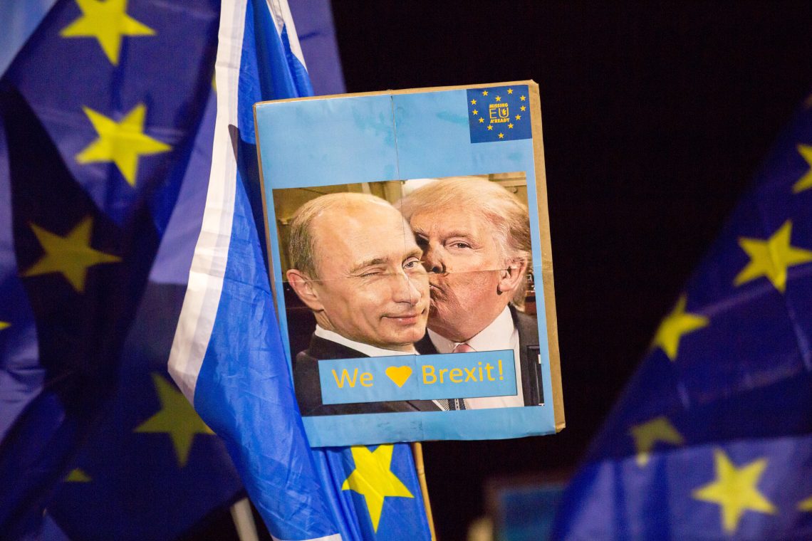 Ein Plakat, das Donald Trump zeigt, wie er Wladimir Putin küsst. Das Plakat wird bei der „Missing EU Already“ Anti-Brexit Rally vor dem schottischen Parlament in Holyrood Edinburgh am 31. Januar 2020 in Edinburgh hochgehalten. Das Bild illustriert einen Kommentar darüber, inwieweit die Politik sich die Psychologie zunutze machen kann.