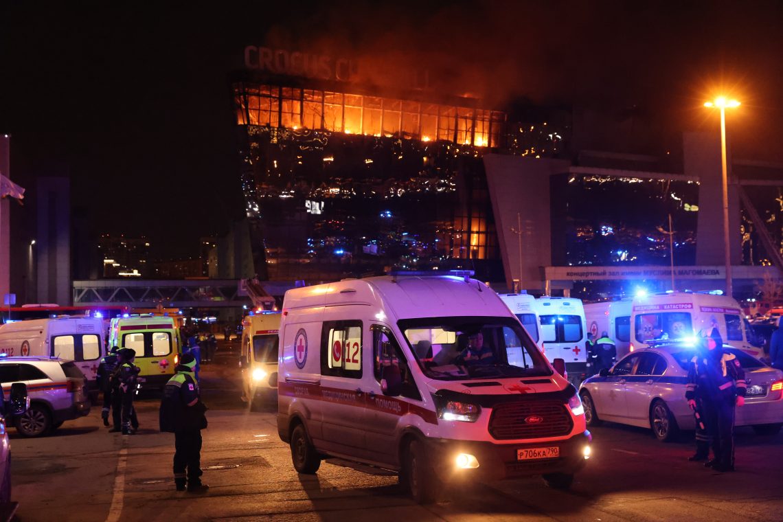 Das Foto zeigt die Crocus City Hall in Krasnogorsk bei Moskau, nachdem mehrere Bewaffnete das Feuer eröffnet hatten. Im Vordergrund sind mehrere Einsatzkräfte zu sehen. Das Bild illustriert einen Artikel über Russland nach dem Terroranschlag am 22.3.2024.