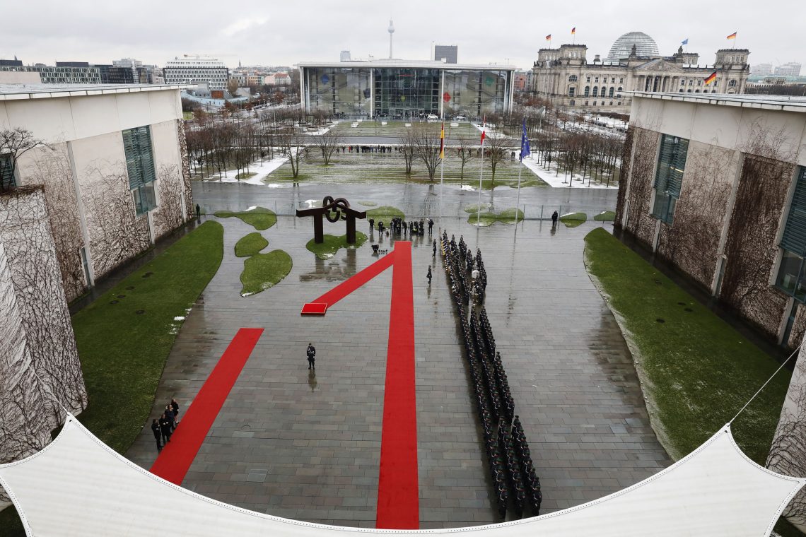 Ein roter Teppich ist vor dem Kanzleramt der Bundesrepublik Deutschland ausgerollt und liegt auf dem nassen Pflaster. Es ist ein regnerischer Tag in Berlin. Das Foto illustriert einen Beitrag über Politik.