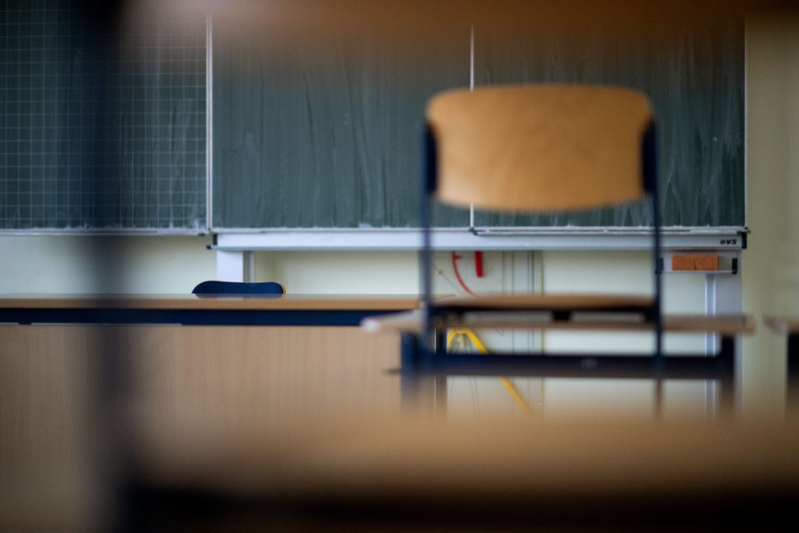 Das Bild zeigt die Tafel und einen Stuhl eines Klassenzimmers. Das Bild illustriert einen Artikel über das österreichische Bildungssystem.