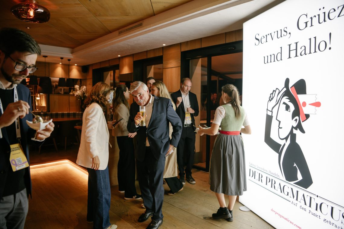 Der Pragmaticus in Alpbach lud am Sonntag den 24.8. in den Alpbacherhof. Auf einem leuchtenden Banner grüßt Der pragmaticus mit "Servus!, Grüezi! und Hallo!"