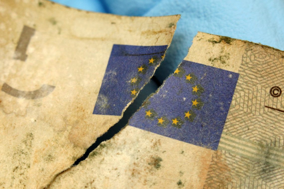 Eine beschädigte Fünf-Euro-Banknote mit einem Riss durch die Europaflagge. Das Bild illustriert einen Kommentar darüber, wie die europäische Komfortzone bröckelt.