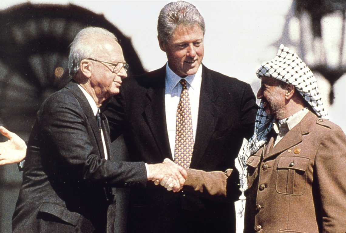 US-Präsident Bill Clinton vor dem Weißen Haus mit dem israelischen Premierminister Yitzhak Rabin (links) und PLO-Chef Yassir Arafat (rechts) nach der Unterzeichnung des Abkommens, mit dem ein Großteil des Westjordanlands in palästinensische Kontrolle überging. Es war der Beginn des Oslo-Prozesses (13. 9. 1993). Das Bild illustriert einen Artikel über Palästina.